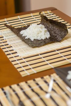 Nori seaweed sheet with rice above ready to make japanese sushi rolls