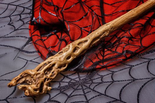 Wooden magic wand is on the web background for halloween