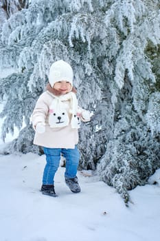 Little cute girl walking in winter forest alone