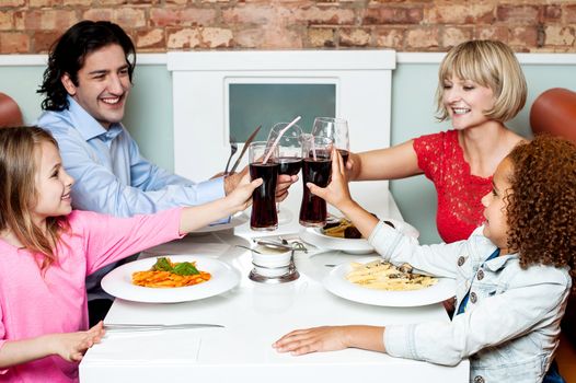 Cheerful family of four celebrating, Cheers!