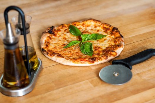 Closeup image of pizza with cutter and tomatoes