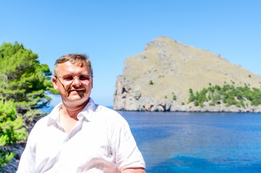 Middle aged man standing on sea coast