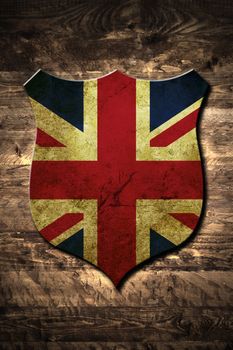 A metal United Kingdom shield on a wooden background