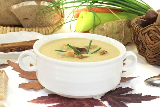 fresh delicious sweet chestnut soup with chives on a light background