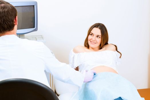 Young attractive pregnant woman on reception at the doctor, health check