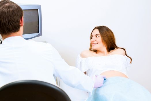 Young attractive pregnant woman on reception at the doctor, health check