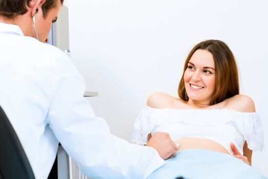 Young attractive pregnant woman on reception at the doctor, health check