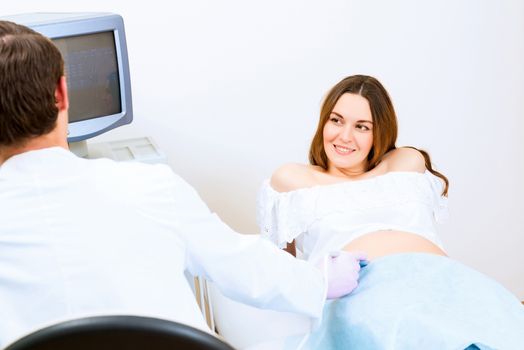 Young attractive pregnant woman on reception at the doctor, health check