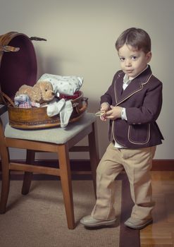 Vintage portrait of cute little boy playing with antique glasses found in a old case. Retro style concept.