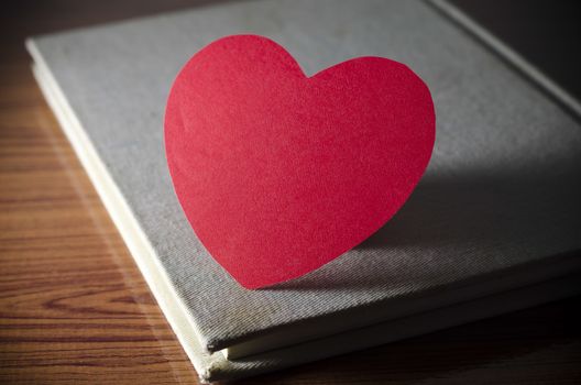 diary of love with notebook and heart on wood background