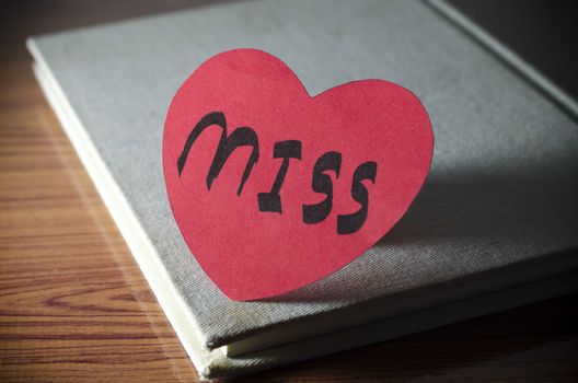 diary of love with notebook and heart on wood background