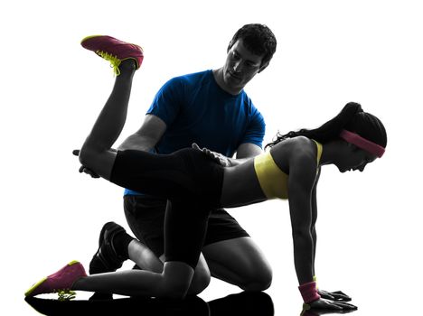 one woman exercising fitness workout with man coach in silhouette on white background