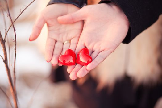 Lovers couple are holding pair of hearts in their hands as a symbol of love