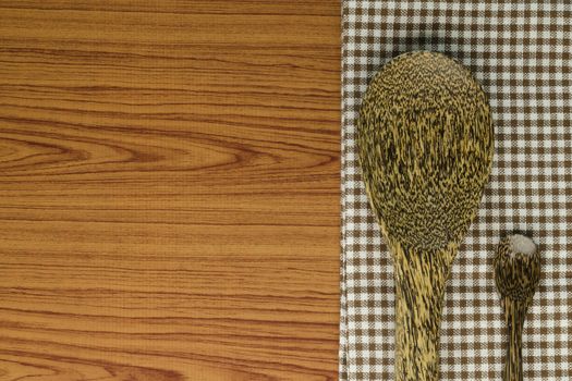 brown kitchen towel with spoon on wood background