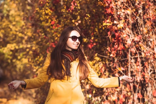 Woman is walking in autumnal park in glasses