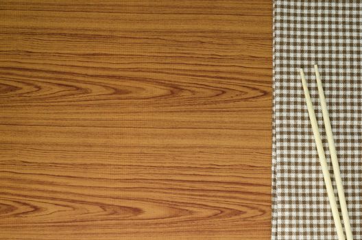 chopsticks with kitchen towel on wood background