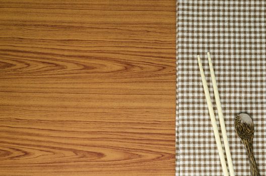 brown kitchen towel with spoon on wood background