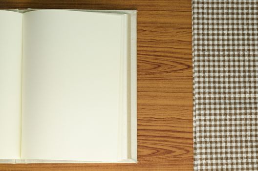 notebook with kitchen towel on wood background
