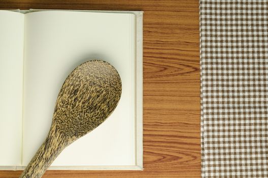 brown kitchen towel with spoon on wood background