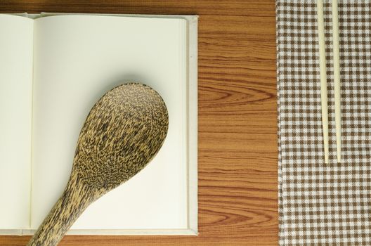 brown kitchen towel with spoon on wood background
