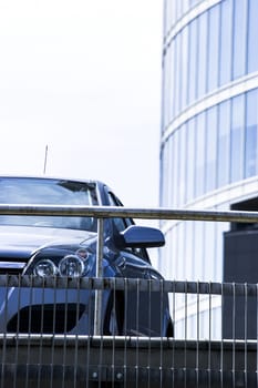 Front view of car in parking place with skyscraper in background