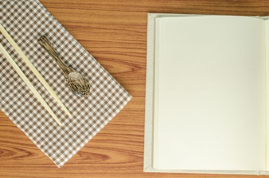 brown kitchen towel with spoon on wood background