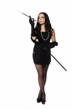 Young woman in retro clothes posing with a cigarette holder, on white background