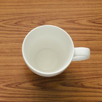 empty coffee cup on brown kitchen towel and wood table