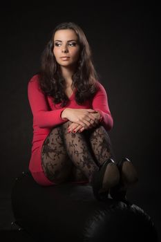 Young woman in pink dress sitting on the punching bag