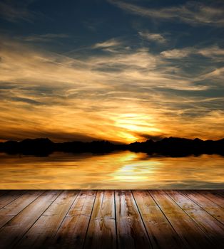 Beauty sunset over a wooden floor and the sea