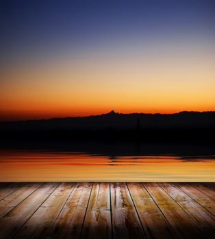Beauty sunset over a wooden floor and the sea