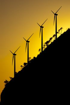 Some wind turbines silhouette in the sunset sky