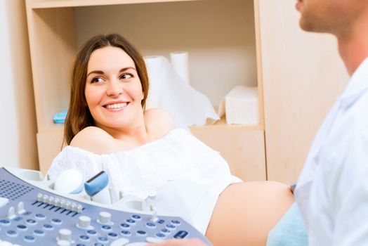 Young attractive pregnant woman on reception at the doctor, health check