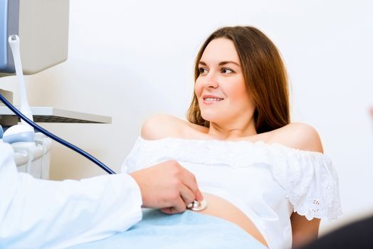 Young attractive pregnant woman on reception at the doctor, health check