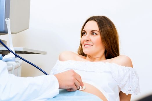 Young attractive pregnant woman on reception at the doctor, health check