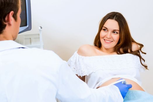 Young attractive pregnant woman on reception at the doctor, health check