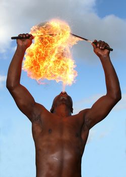 Circus fire-eater blowing a large flame from his mouth