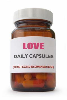 Daily 'love' capsules in a container over a white background 