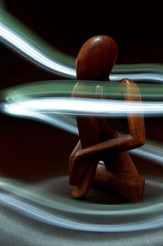 Wooden figure surrounded by light