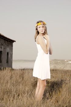 Beautiful young woman in a meadow wearing a crown of flowers