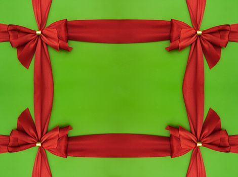 Bow of red satin ribbon on a green background