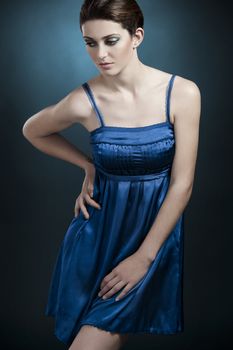 Sexy and beautiful fashion woman posing against a blue background