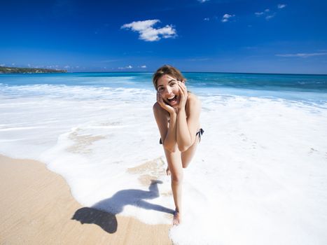Beautiful and happy young woman  enjoying the summer on a tropical beach 