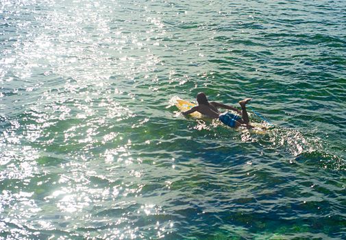 SIARGAO, PHILIPPINES - MAY 07, 2012: Two unidentified young surfers carrying surfboards at Cloud Nine surf point in Siargao, Philippines. In 2011 3.9 million tourists visiting the country.