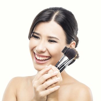 Beauty portrait of an Asian young woman holding make-up brushes