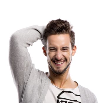 Casual portrait of a young man laughing isolated over a white background