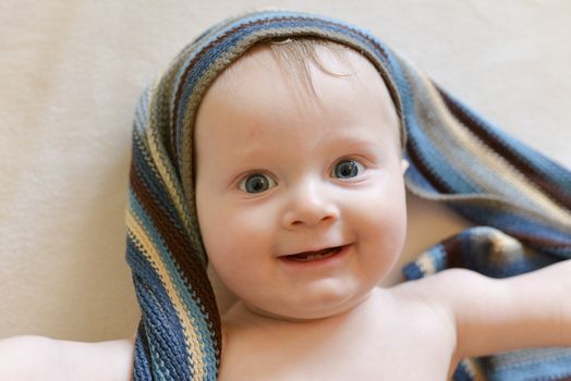 Portrait of a seven month old baby boy looking curious at the camera