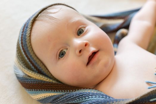 Portrait of a seven month old baby boy looking curious at the camera