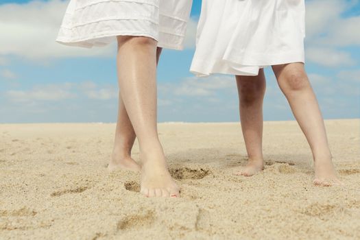 Woman and her little daughter on the beach