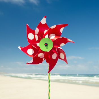 Red windmill with a beach as a background